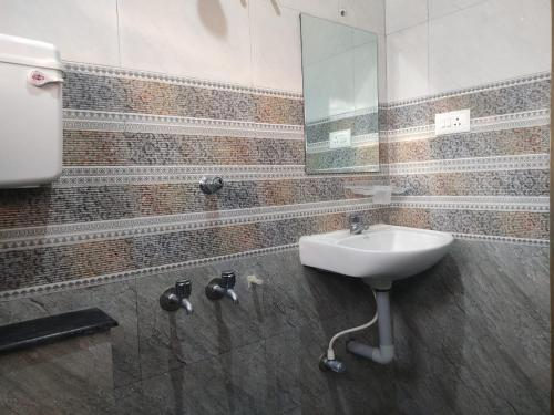 a bathroom with a sink and a mirror at Balaji Lodge in Villupuram