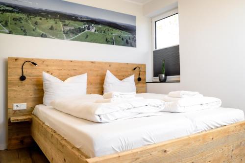 1 dormitorio con 1 cama grande con almohadas blancas en Smart Resorts Haus Saphir Ferienwohnung 512, en Winterberg