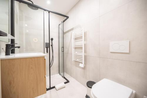 uma casa de banho com um chuveiro, um WC e um lavatório. em MBM - Bastille Marais em Paris