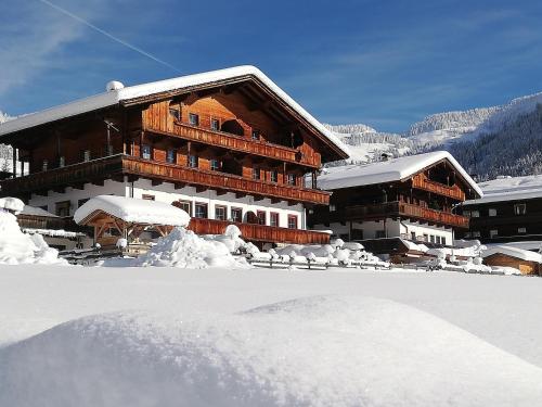 a large wooden building with snow on the ground at Appartement Moaeben in Alpbach