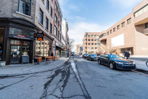 a city street with cars parked on the street at INITIAL - MEMORY FACTORY - Centre-Ville de Québec in Quebec City