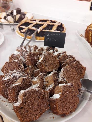 a plate of brownies and pies on a table at Hotel Caesar in Pesaro