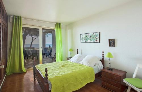 Schlafzimmer mit einem Bett mit grüner Tagesdecke in der Unterkunft Villa Les 3 frères in San-Nicolao