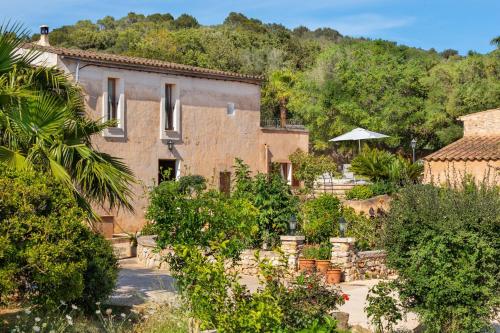 an old house with a garden in front of it at Finca Cavea in Caʼs Concos