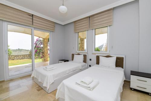 Dos camas en una habitación con dos ventanas. en Villa Moonlight, en Karadere