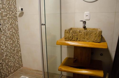 a bathroom with a sink and a shower at Refúgio do Caracol Pipas e Chalés in Canela