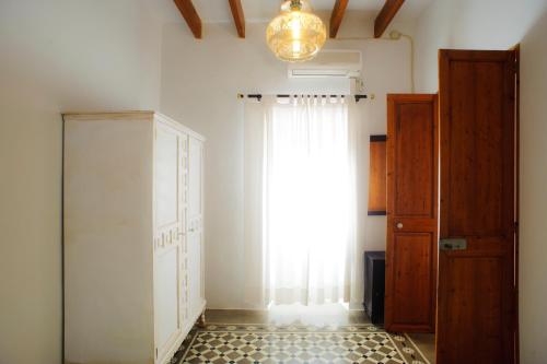 a room with a large window and a curtain at Finca Cavea in Caʼs Concos
