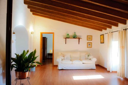 a living room with a white couch and wooden floors at Finca Cavea in Caʼs Concos