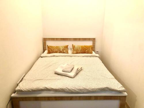 una piccola camera da letto con un letto e un asciugamano sopra di PAU18 Apartments a Budapest