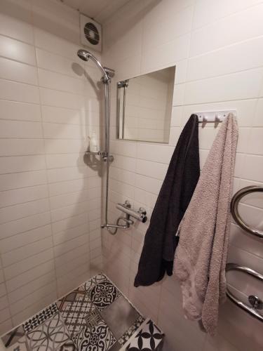 a bathroom with a shower and a tile floor at Saulėlydžio Apartamentai in Panevėžys