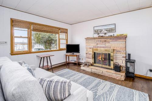 a living room with a couch and a fireplace at Bwthyn Traeth in Beulah