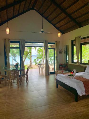 a bedroom with a bed and a table and chairs at Moon Beach Villas El Nido in El Nido