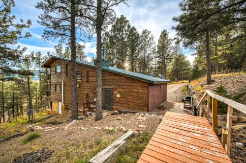 a log cabin in the woods with a wooden bridge at Bigfoot Lodge in Angel Fire