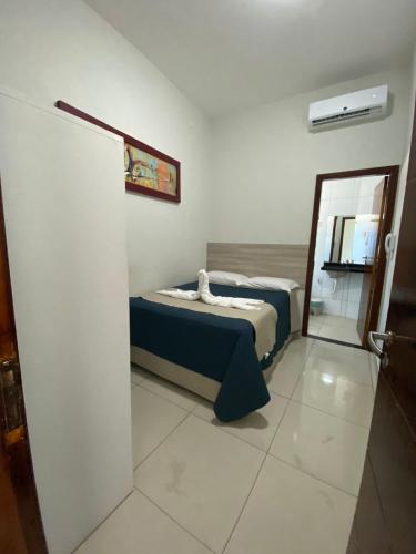 a small bedroom with a bed and a mirror at Pousada Orla dos Corais in Maragogi