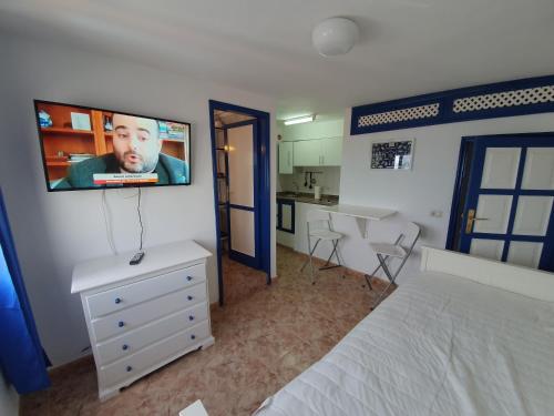 a bedroom with a bed and a tv on the wall at Relaxlanzarote in Punta de Mujeres