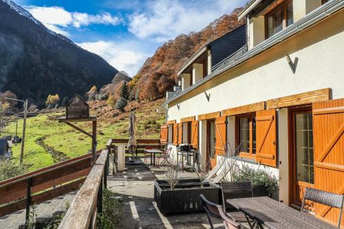 - un bâtiment avec une terrasse dotée d'une table et de chaises dans l'établissement Ô Chiroulet - Le Refuge de l'Isard, à Bagnères-de-Bigorre