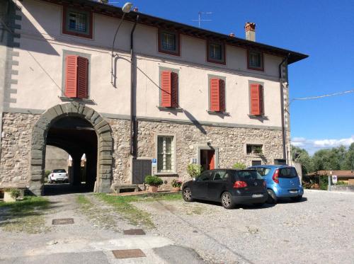 due auto parcheggiate di fronte a un edificio con persiane rosse di Antica Casa Fenaroli a Iseo