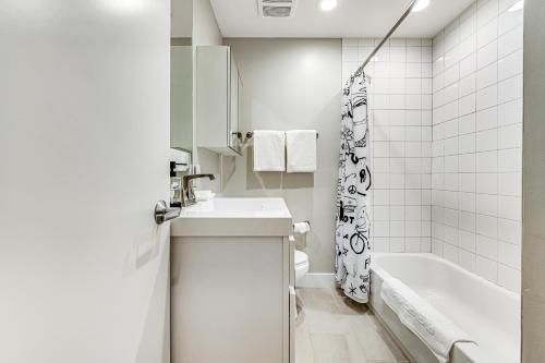 a white bathroom with a sink and a tub at Blue Cactus Getaway in Scottsdale