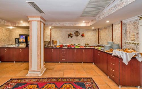 a kitchen with wooden cabinets and a counter with food at Santa Sophia Hotel - İstanbul in Istanbul