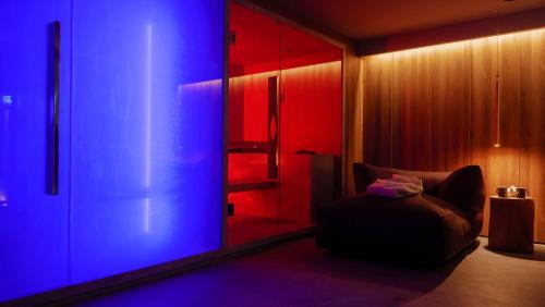 a room with red and blue lights and a chair at Hotel Nido dell'Aquila in Assergi