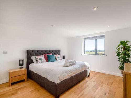 a bedroom with a large bed and a window at 2-Bed Modern Bungalow - Outstanding Country Views in Harrogate