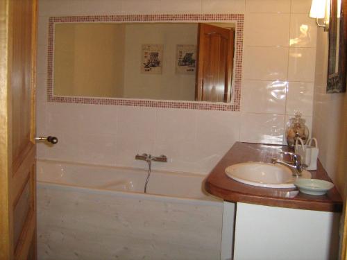 La salle de bains est pourvue d'une baignoire, d'un lavabo et d'un miroir. dans l'établissement Moulin de la Génetée, à Saint-Aubin-sur-Scie