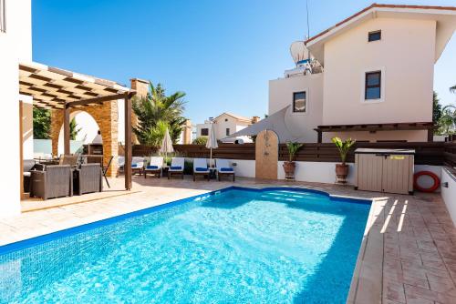 een villa met een zwembad en een huis bij Villa Iris by Ezoria Villas in Ayia Napa