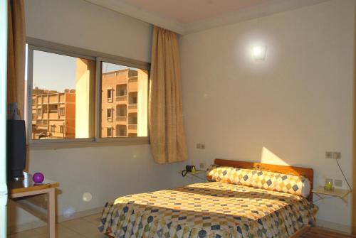 Hotel Aladarissa Ait Baha في Aït Taksimt: غرفة نوم بسرير ونافذة كبيرة