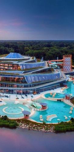 un grand bâtiment avec une grande piscine dans l'établissement Calme Studio & WIFI Jardin Disneyland Paris 4 personnes, à Faremoutiers