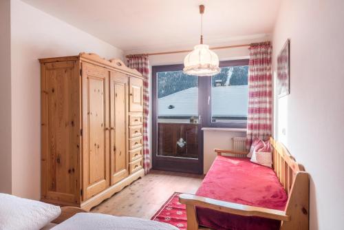 une chambre avec un lit et une grande fenêtre dans l'établissement Casa Rustica App Saslonch, à Ortisei