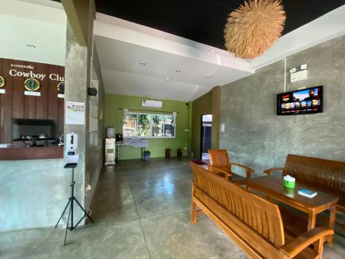 a lobby with a bench and a table and a television at Preme Apartment @maejo in Ban Pa Lan