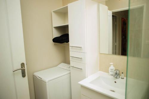 a white bathroom with a sink and a mirror at Créteil. Au pied du lac. T4 de 67 m2 in Créteil