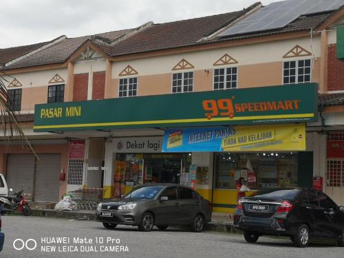 two cars parked in front of a store at TB HOMESTAY Tasek klebang(taman bertuah) 10pax wifi in Chemor