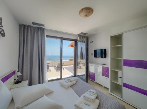 una camera con letto e vista sull'oceano di Sky Sea Resort Skiathos a Città di Skiathos