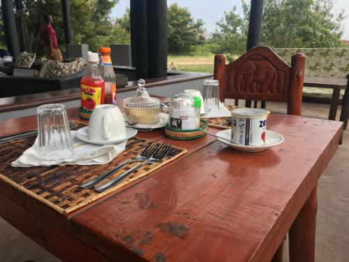 einen Holztisch mit Küchenutensilien darüber in der Unterkunft Enshama Game Lodge and Campsite in Katunguru