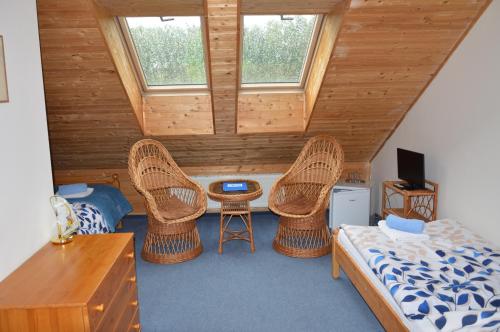 a bedroom with wicker chairs and a bed and a table at Penzion Krcma in Dolní Morava