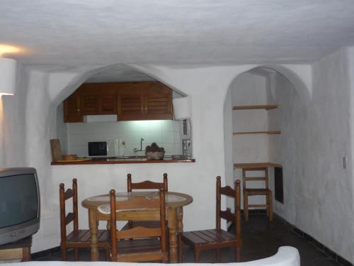a dining room with a table and chairs and a tv at Club Hotel Casapueblo in Punta del Este