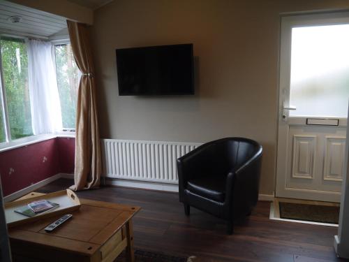 un soggiorno con sedia nera e tavolo di Rodeen self-catering apartment a Castletownbere