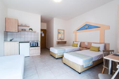 a large room with two beds and a kitchen at Ilios Malia Hotel Resort in Malia