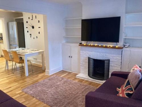 a living room with a fireplace with a tv above it at Gulliver's Cottage in Frinton-On-Sea in Frinton-on-Sea