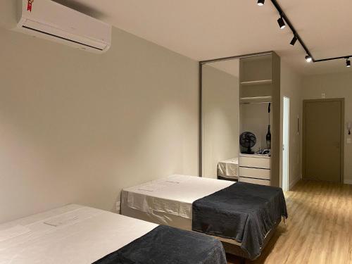 a room with two beds and a mirror at Locking's Santo Agostinho 2 in Belo Horizonte