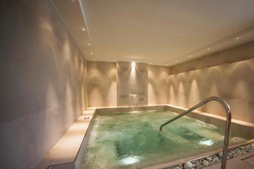 een badkamer met een jacuzzi met een metalen rail bij Riviera Mare Beach Life Hotel in Rimini