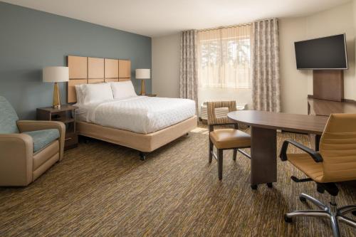 a hotel room with a bed and a desk at Candlewood Suites Vancouver/Camas by IHG in Vancouver