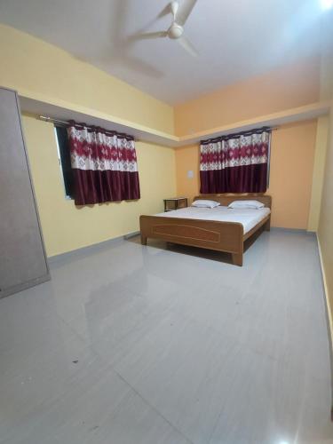 a bedroom with two beds and a ceiling fan at Alpine Green in Rānchī