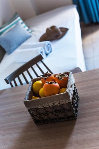 a basket of fruit sitting on a table next to a bed at Ilios Malia Hotel Resort in Malia
