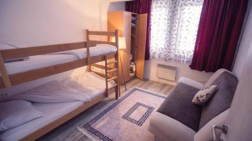 a small room with two bunk beds and a couch at Aber Apartmani Kopaonik in Kopaonik