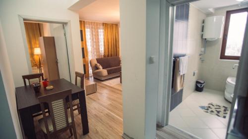 a living room with a table and a couch in a room at Aber Apartmani Kopaonik in Kopaonik