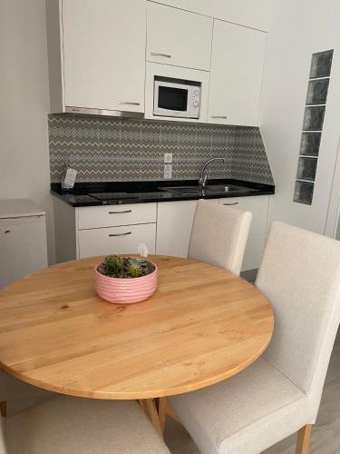 a wooden table with two chairs and a bowl on it at Hotel Neptuno in Peniche