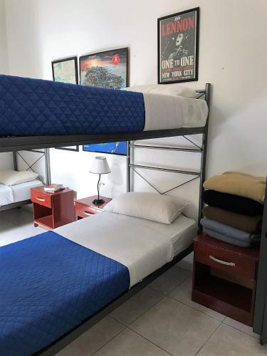 a bedroom with two bunk beds with blue sheets at Reina Madre Hostel in Buenos Aires