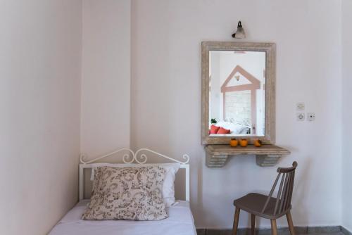 a bedroom with a bed and a mirror and a chair at Ilios Malia Hotel Resort in Malia